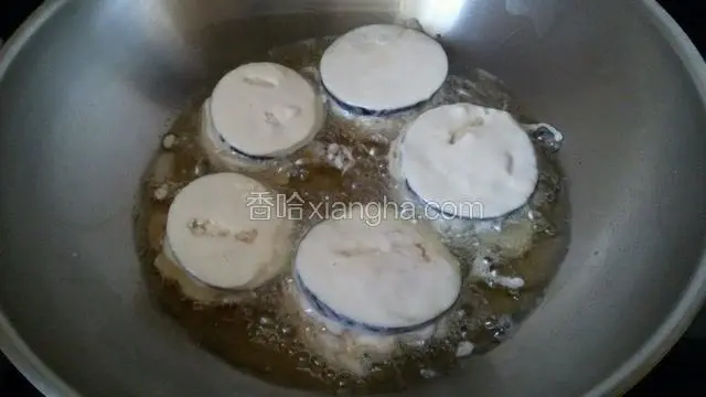 锅中放花生油温到四五成热时把茄夹放进去炸。