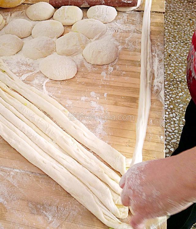 取一个饧好的面条，用手扯住两端向外拉伸一下