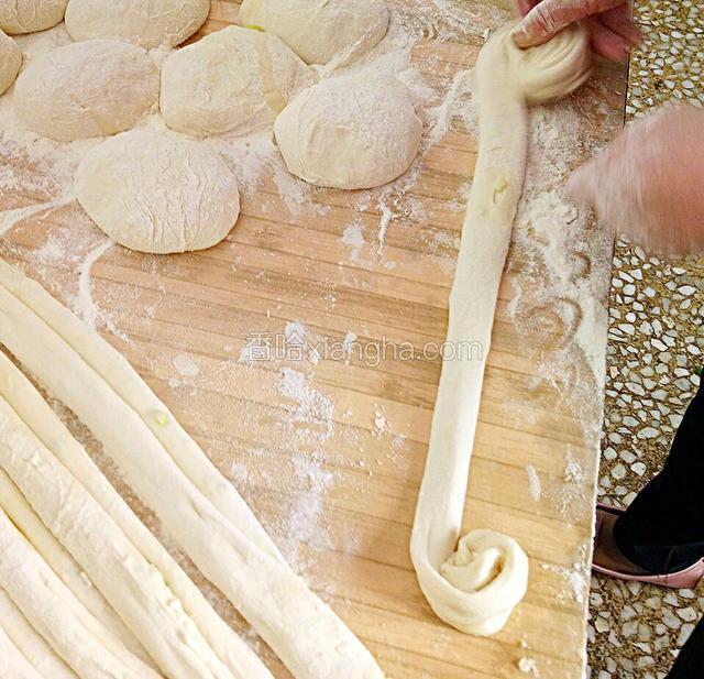 然后分别从两端向中间卷起，如图所示