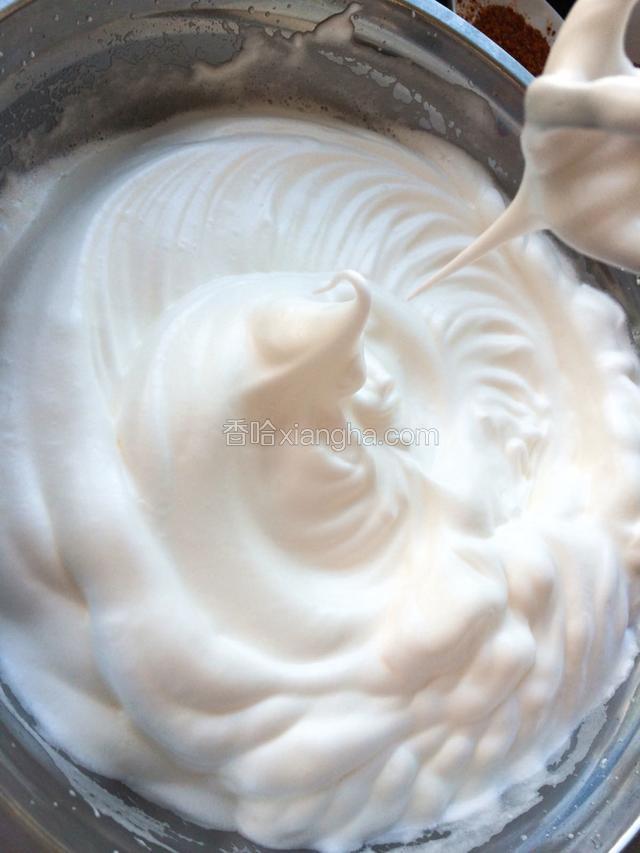 蛋白加三分之一的糖打发到出现鱼眼泡时再加入剩下糖的一半继续打至出现大量泡沫时倒入余下的糖，提起打蛋器蛋白尖自然弯曲就好了，如图！