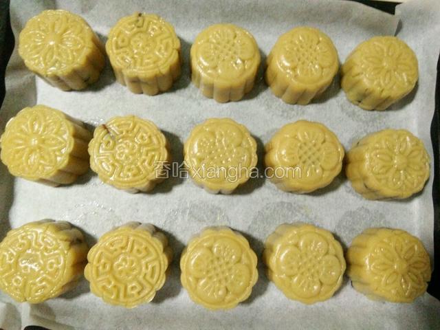 依次做好全部生坯，放在铺好油纸的烤盘里，喷点雾水在月饼生坯上