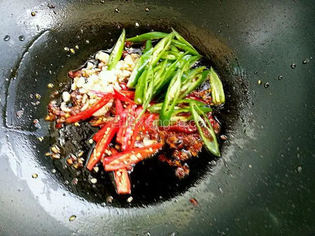 放入线椒和小米椒，翻炒出辣味