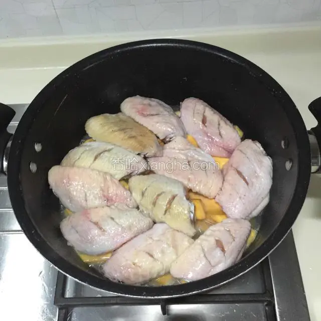 在红薯上面摆上鸡翅，盖上锅盖焖煮20分钟