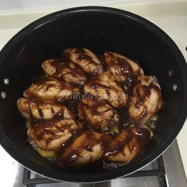 焖煮20分钟后，在鸡翅上均匀涂抹酱汁，两面都要涂抹上，剩下的酱汁淋在红薯上面盖上锅盖焖煮20分钟即可
