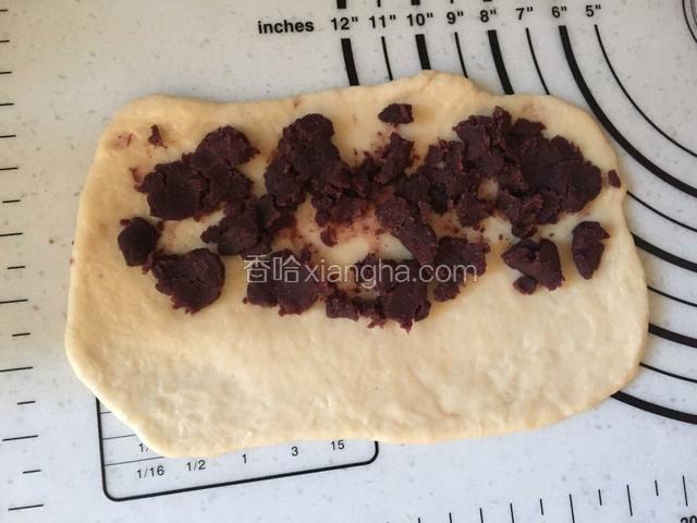 松弛好的面团按扁，擀薄，一头放适量豆沙，不要全部都放满，放一边就可以