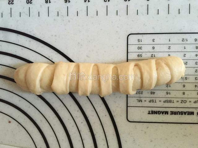 在没放豆沙的那边用刮刀均匀切开一条条的（忘记拍图了）由豆沙那边开始卷起，切开的面团一点点卷过来，压到底部