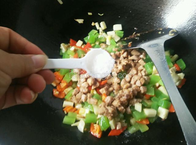倒入肉丁并调入盐翻炒均匀