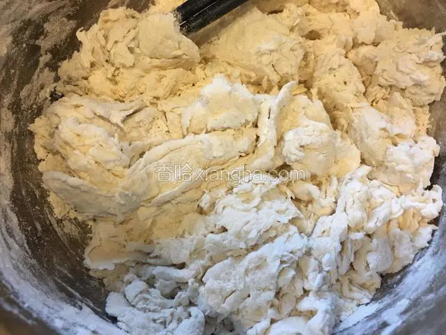面粉中缓缓加入温水，用筷子搅拌成絮状。
