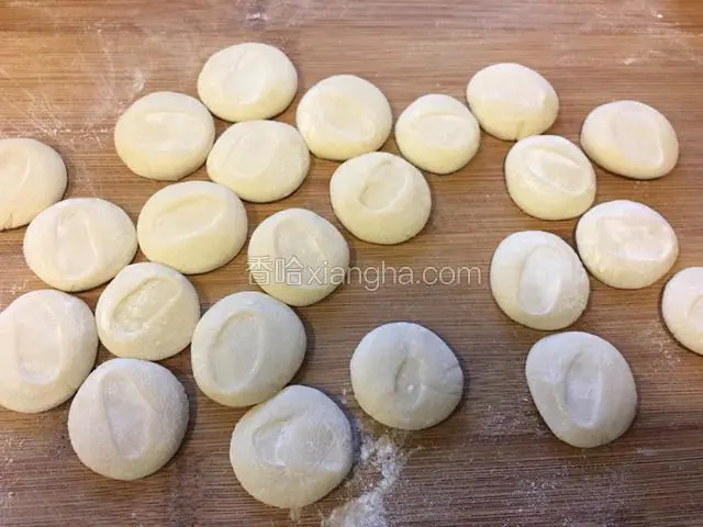 剂子上撒薄粉，把剂子按扁。