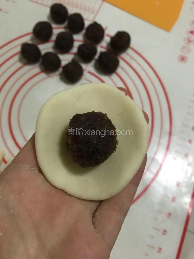 面皮压平，擀成圆形，包入豆沙。