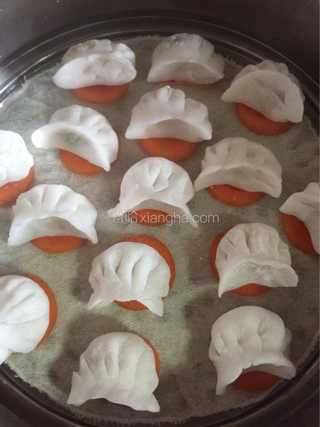 每个饺子底部放一片胡萝卜，为的是不粘屉布。