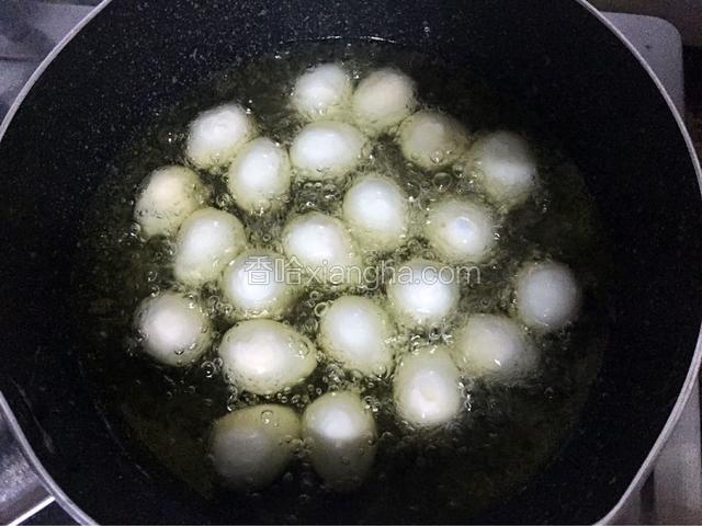 锅中倒入适量西王玉米胚芽油烧至六七成热时一个一个放入鹌鹑蛋，