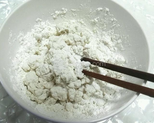 糯米粉里加入60℃左右的热水，用筷子搅拌成大颗粒状。