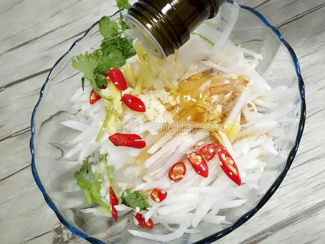切好的佐料放在萝卜丝上面，同时添加盐，生抽，胡椒粉，花椒油，芝麻油，橄榄油，白糖，辣椒油。