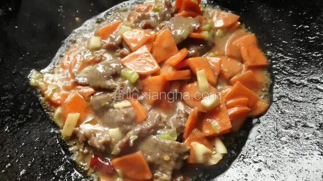 牛肉熟后放入胡萝卜煸炒。