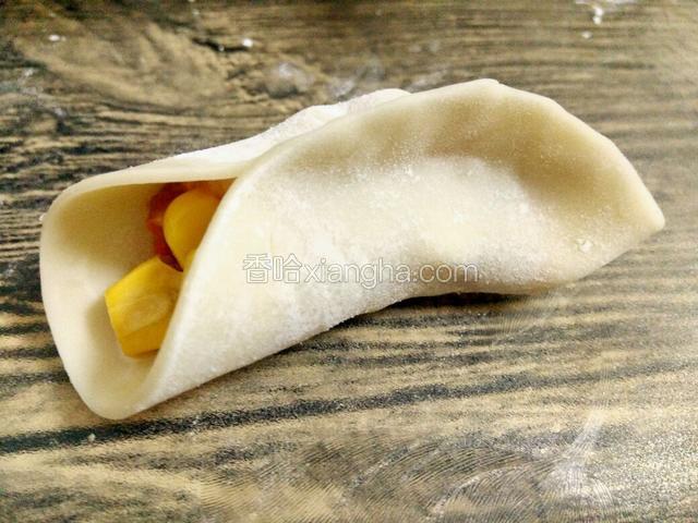 右手大拇指慢慢跟着饺皮移动，保持前面饺皮平整