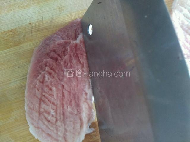 然后用刀背敲肉片。