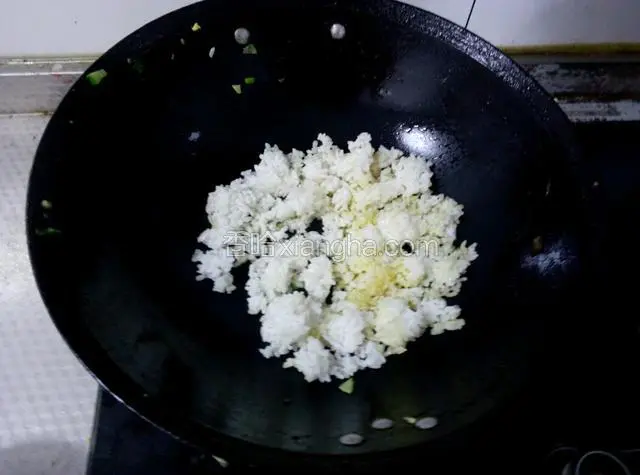 锅里放入少许食用油，倒入米饭炒散。