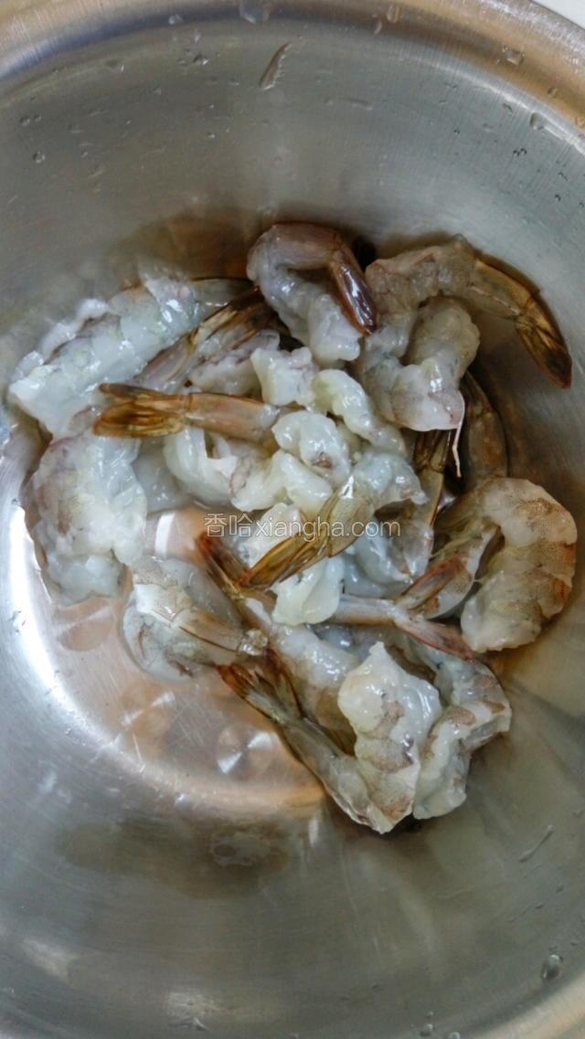把弄好的虾从肚子切开不要切断轻轻拍打，全部拍完之后放入水里清洗