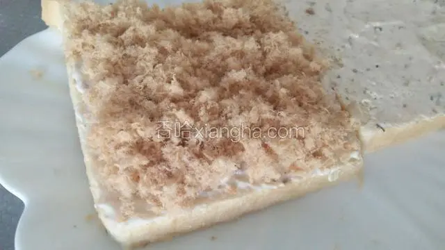 在其中一片铺满沙拉酱的吐司上面，均匀的铺上肉松，肉松的多少根据各人喜好，或多或少都可以，我铺的肉松很多，是我自己做的肉松，很好吃