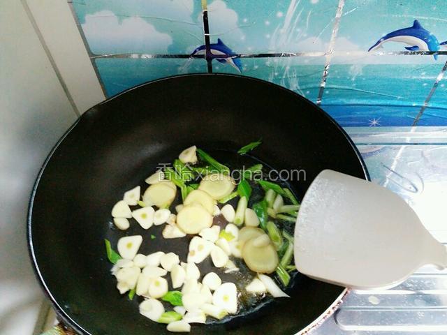 再开大火倒油烧热，煸炒姜蒜片和蒜苗。