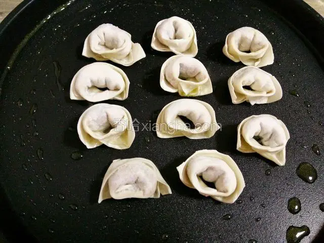 把油推开均匀，放入馄饨，小火煎（电饼档的朋友按烙饼键）