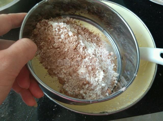 把低粉和可可粉筛入蛋黄盆，一边筛一边搅拌，少量拌匀再继续筛入，这样不容易起颗粒。