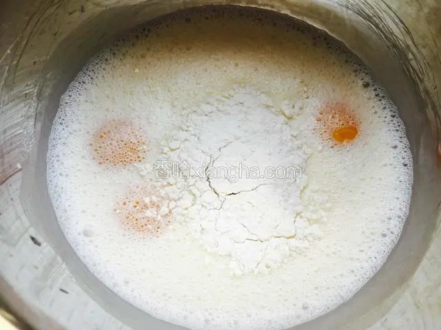 等液体冷却到不烫手就可以了，加入蛋黄和低筋面粉，用手动打蛋器搅拌均匀无颗粒。