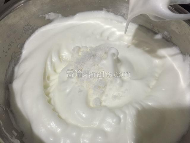 继续打发到提起打蛋器能拉出小弯勾，加入剩下的20克白糖。