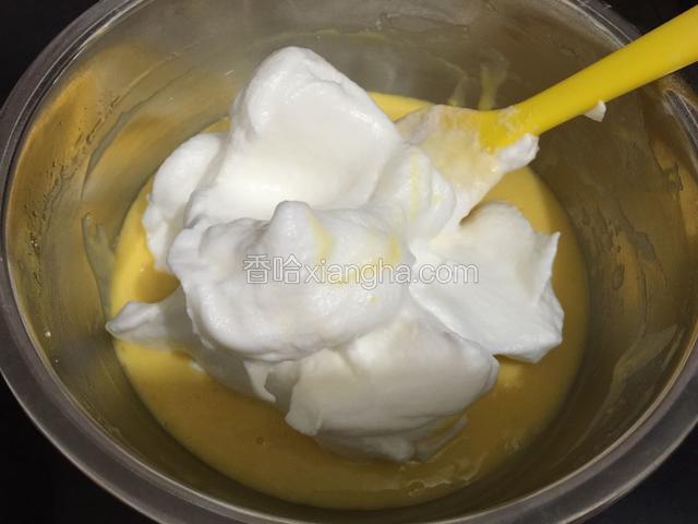 取三分之一的蛋白霜到蛋黄糊里，用刮刀从下往上的翻拌均匀。