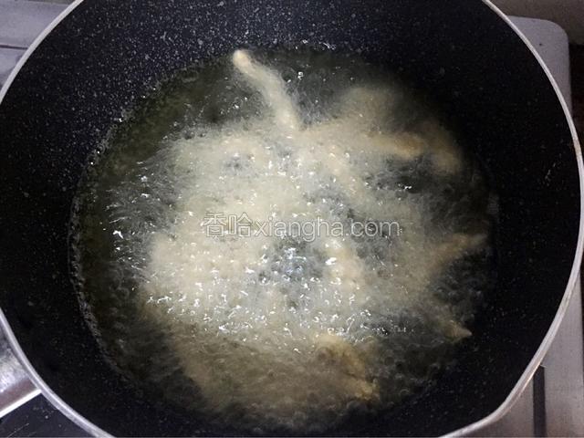 锅中倒入适量油烧至六成热时放入鸡柳，中小火炸至金黄色