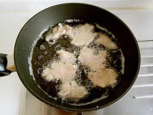 将肉片一片片展开放入锅中，炸至五六成熟时捞出。