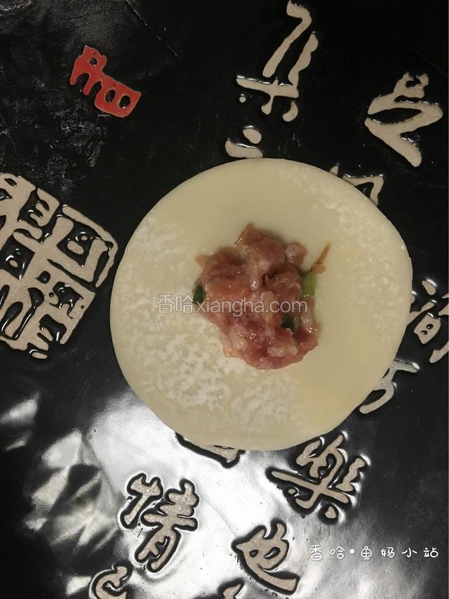 在饺子皮的中间位置放入适量的肉馅......