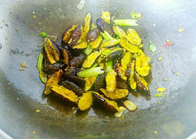放入蚕蛹，快速翻炒均匀，撒上芝麻出锅即可。