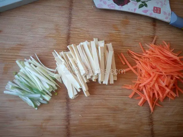 把胡萝卜刨丝（或者切丝），豆腐干切薄片，葱切丝备用。