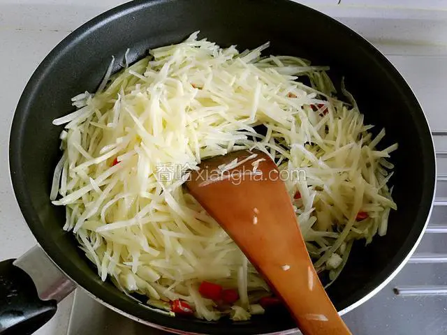 然后把土豆丝放下去用大火翻炒，倒一点啤酒或料酒下去继续翻炒。