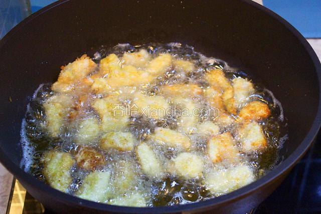 油锅烧至五成热，快速下入鸡肉条炸制