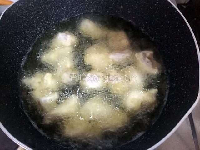 锅中倒入适量油烧至六七成热时放入鸡块，小火炸至淡黄色