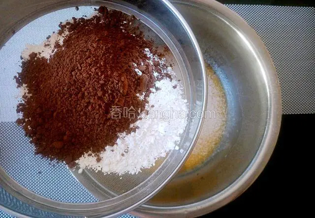 可可粉和低筋粉混合后筛入蛋黄液内。
