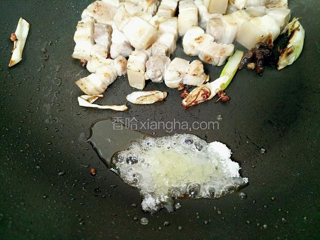 把锅侧一边加点油，肉放一边。加入白糖炒化，后翻动肉上色。