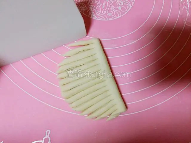 用刀切出与对折线垂直的细条，整边一侧不要切断。