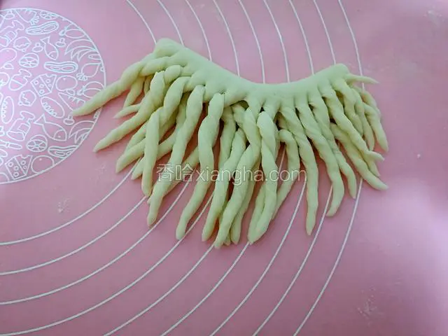拽起一个切好的细条，从头螺旋状拧至未梢，每根都如法炮制，圣诞老人的大胡子就成型了。