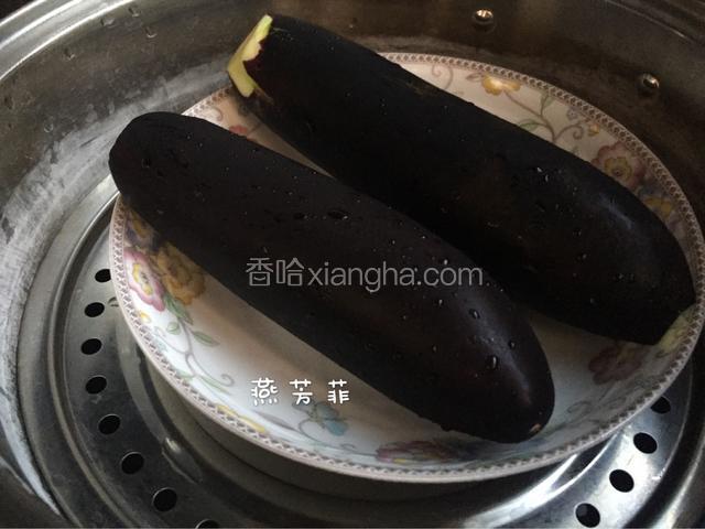 茄子掰掉蒂，洗干净外皮，上锅上汽蒸15分钟。