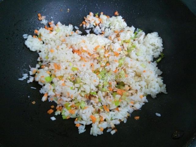 翻炒一会至米粒散散的，倒几种蔬菜丁继续翻炒均匀。下蔬菜丁之后改大火快速翻炒，蔬菜丁会炒出水分要大火快炒。（大火）