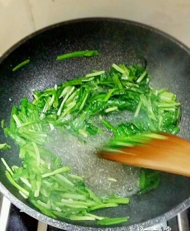 动作很快的倒入炒好的粉丝，将粉丝和韭菜快速炒匀，加入适量鸡精。