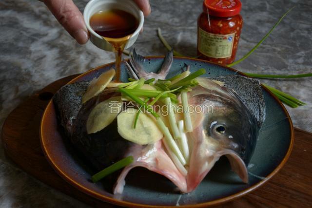 用姜片、葱段和料酒将鱼头腌制10分钟。