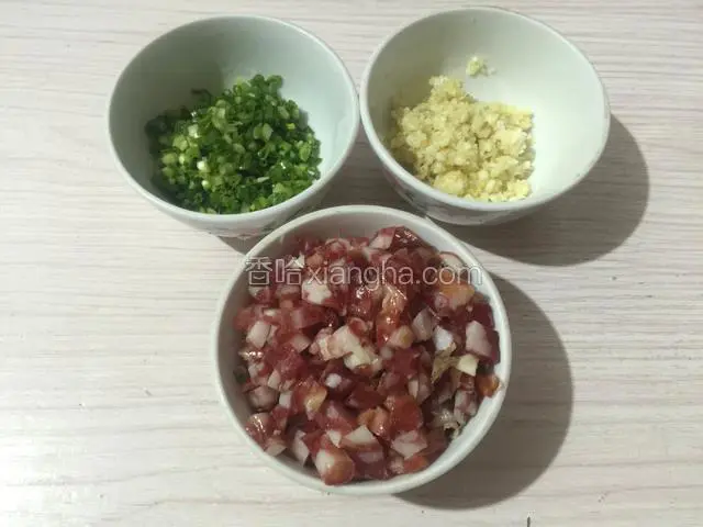 将香肠切成小颗粒，蒜瓣和姜片切成碎末，葱切成细末备用；