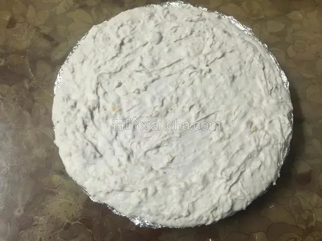将搅拌好的芋头糊倒入披萨烤盘中，抹平表面，端起盘子震动几下让它成固定状态；