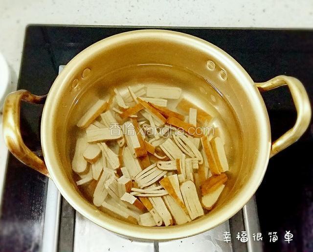 豆腐干切成小块，放入锅中焯下水。