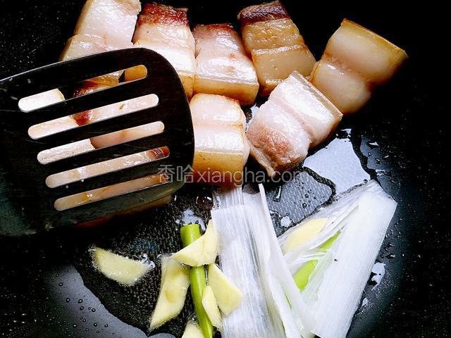 五花肉煎好后，用锅铲把五花肉拨至锅的一边，用煎出来的油把葱姜煸香。